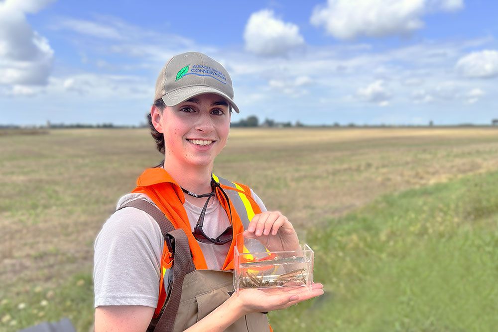Ben Harter, Junior Conservationist, in front of a field.